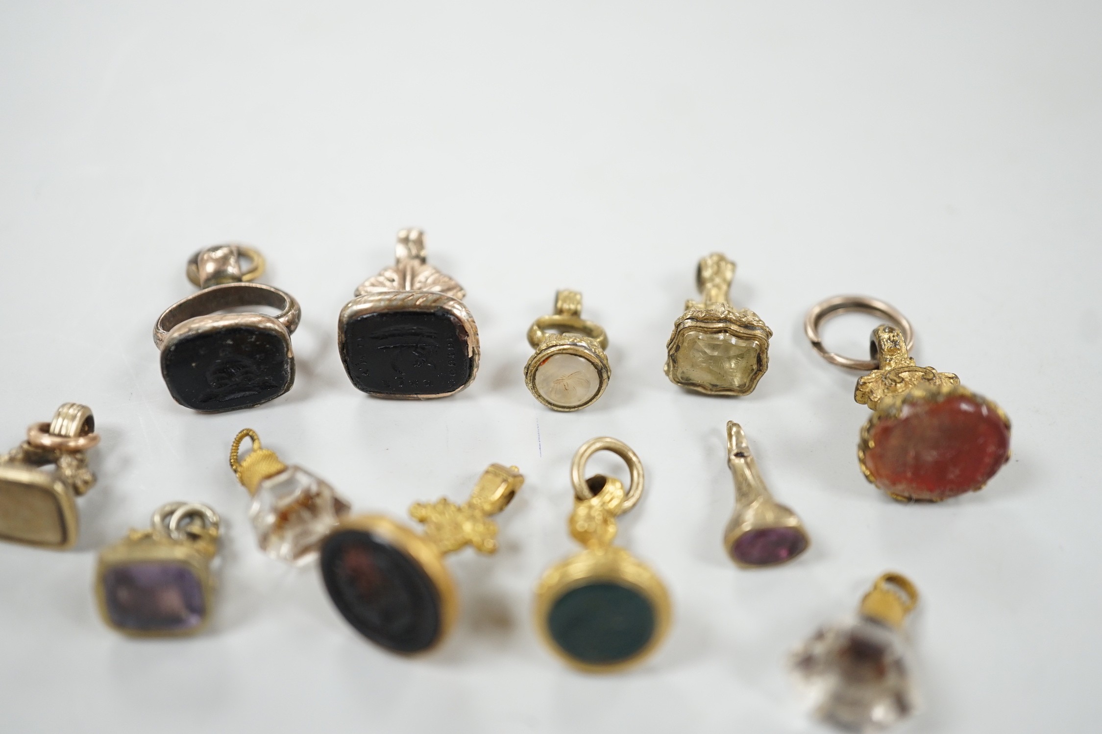 A collection of twelve small 19th century mainly yellow metal fob seals, with assorted matrices including bloodstone, amethyst, citrine and carnelian, largest 22mm.